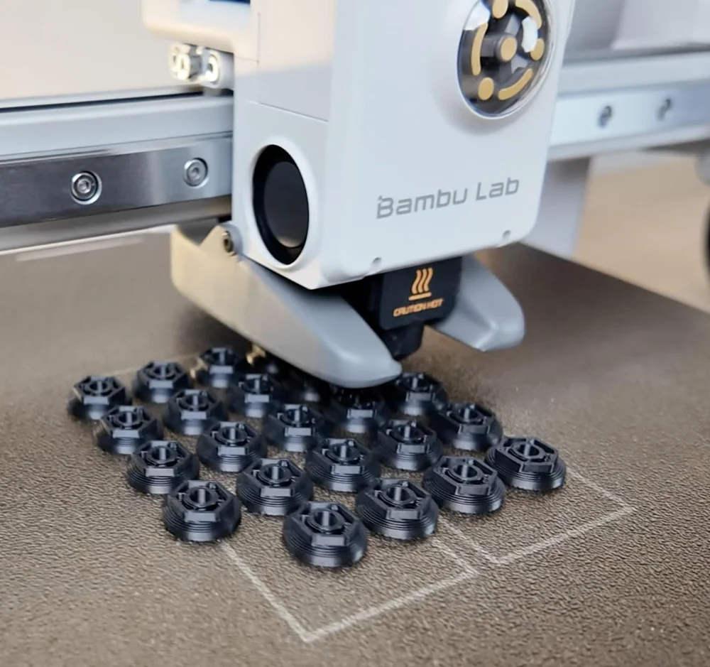Lote de engrenagens pretas recém-impressas em 3D na mesa da impressora